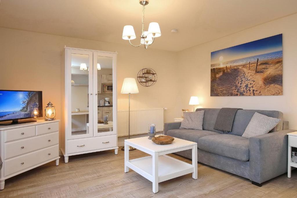 a living room with a couch and a tv at Strandvilla Krabbe Wohnung 03 in Boltenhagen