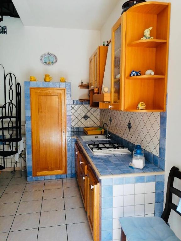 a kitchen with wooden cabinets and a stove top oven at Appartamento Peralta 20 in Centro in San Vito lo Capo