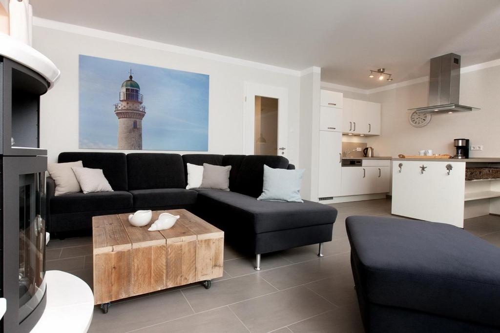 a living room with a black couch and a lighthouse at Reethaus Am Mariannenweg 11a in Boltenhagen