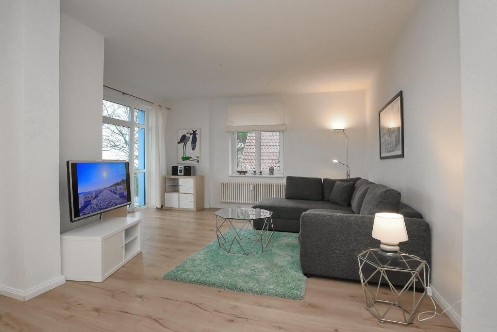a living room with a couch and a television at Villa Triton Wohnung 04 in Boltenhagen