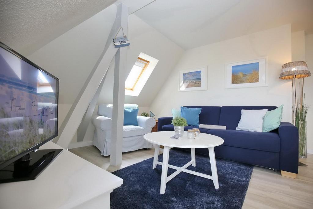 a living room with a blue couch and a table at Villa Triton Wohnung 06 in Boltenhagen