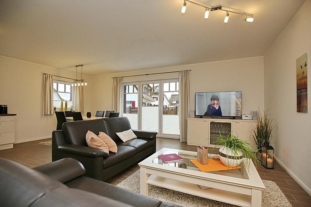 a living room with a couch and a tv at Reethaus Am Mariannenweg 20a in Boltenhagen