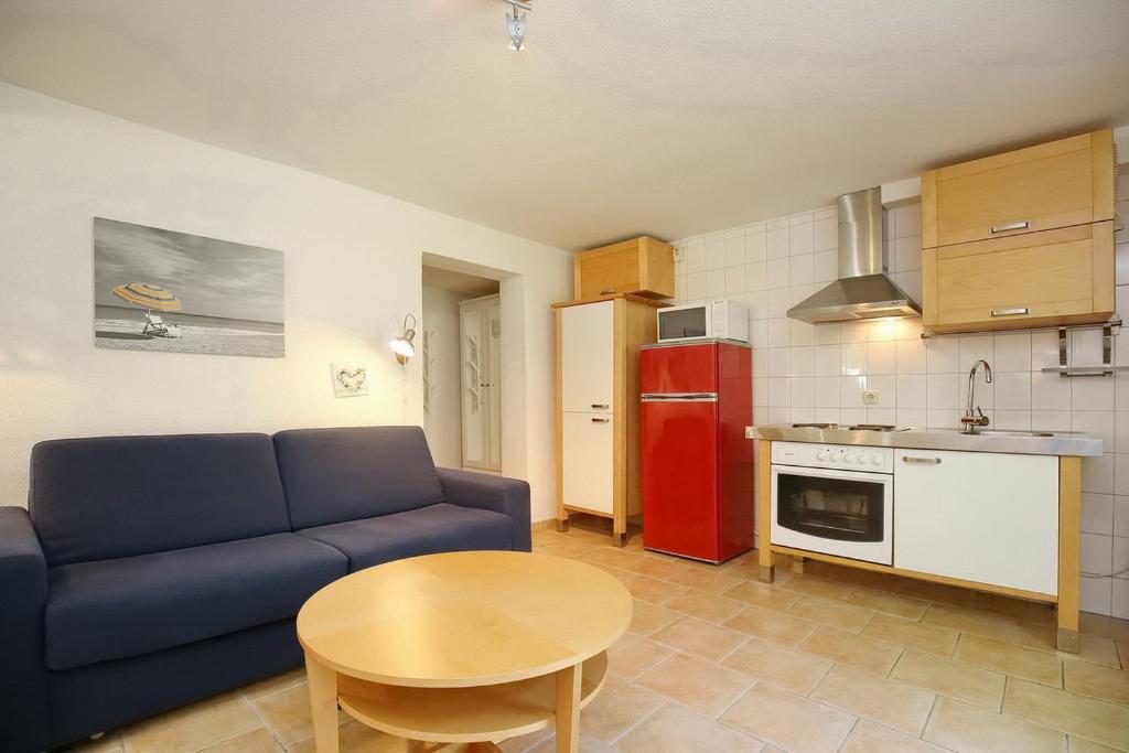 sala de estar con sofá, mesa y cocina en Villa Triton Souterrain Wohnung 08, en Boltenhagen