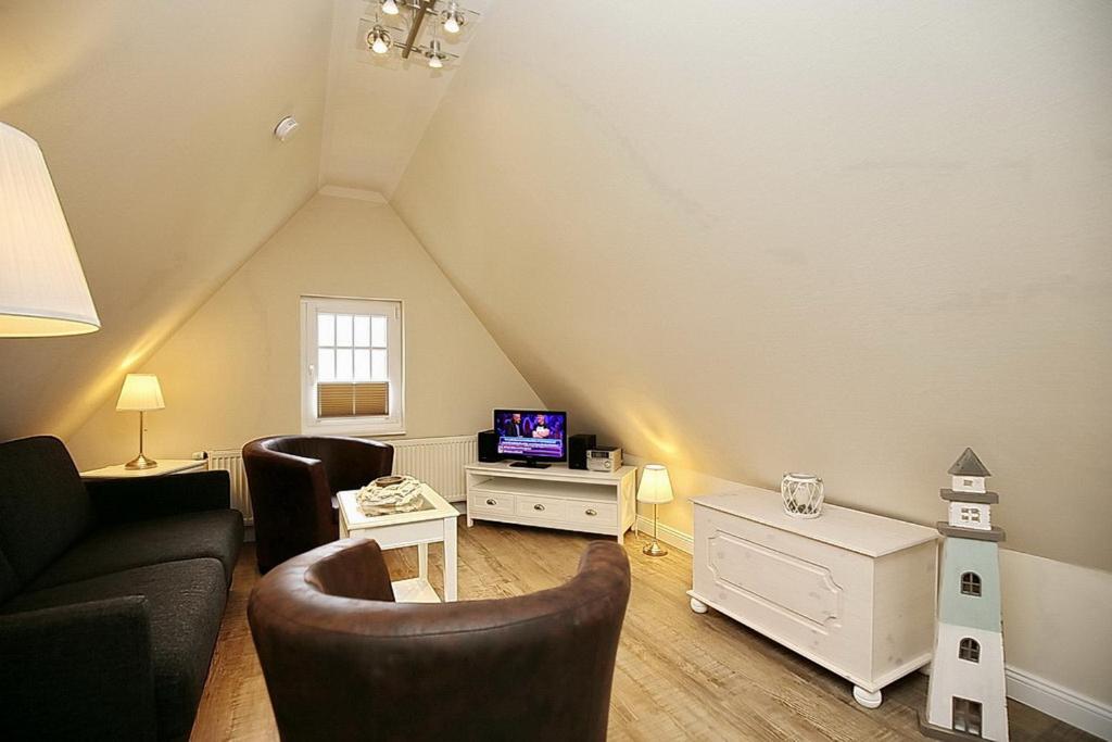 a living room with a couch and a tv at Strandvilla Krabbe Wohnung 07 in Boltenhagen