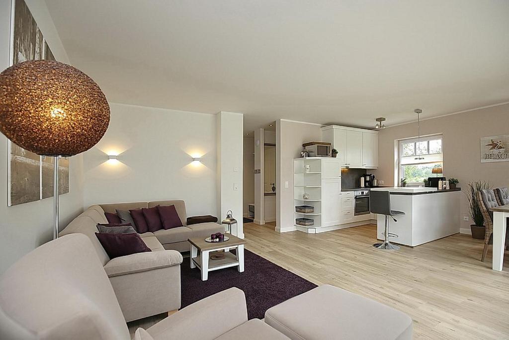 uma sala de estar com um sofá e uma mesa em Reethaus Am Mariannenweg 09b em Boltenhagen