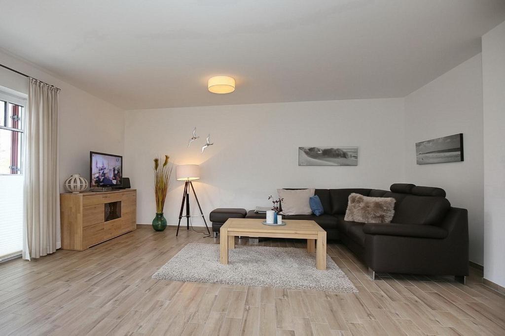 ein Wohnzimmer mit einem Sofa und einem Couchtisch in der Unterkunft Reethaus Am Mariannenweg 19a in Boltenhagen