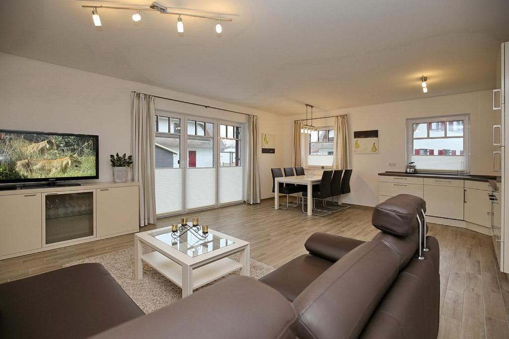 uma sala de estar com um sofá e uma mesa em Reethaus Am Mariannenweg 04b em Boltenhagen