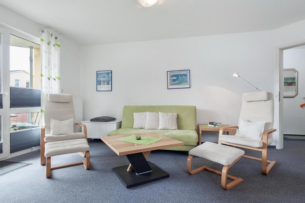 a living room with a couch and two chairs and a table at Godewind Wohnung 27 in Boltenhagen