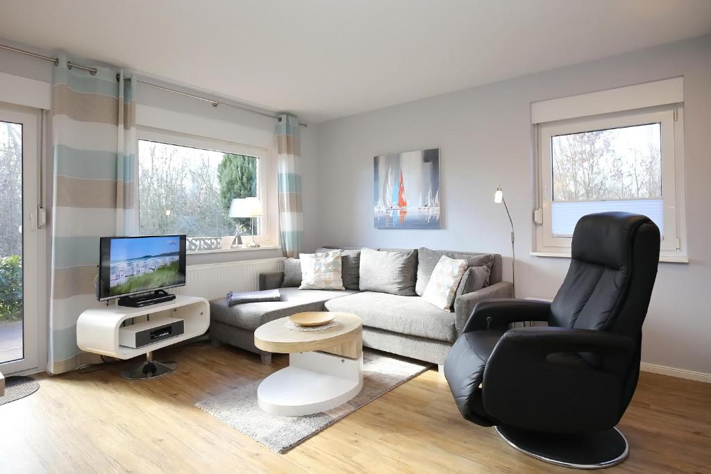 a living room with a couch and a chair at Urlauberdorf Haus 41d in Boltenhagen