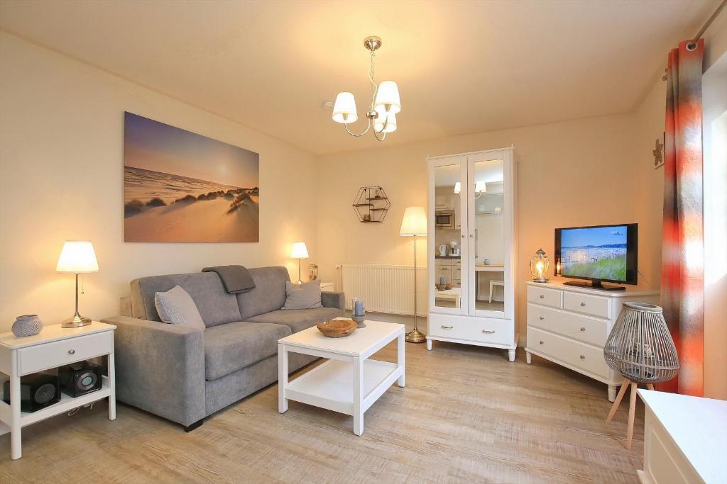 a living room with a couch and a tv at Strandvilla Krabbe Wohnung 02 in Boltenhagen