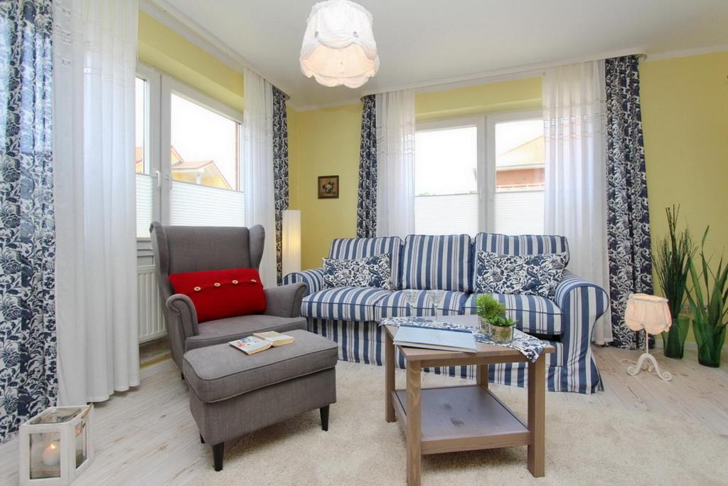ein Wohnzimmer mit einem Sofa und einem Stuhl in der Unterkunft Goosbrink Wohnung 27 in Boltenhagen