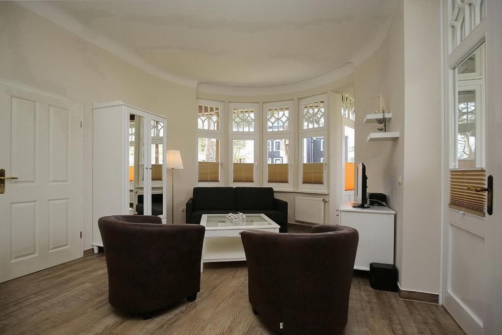 a living room with a couch and a table and chairs at Strandvilla Krabbe Wohnung 04 in Boltenhagen