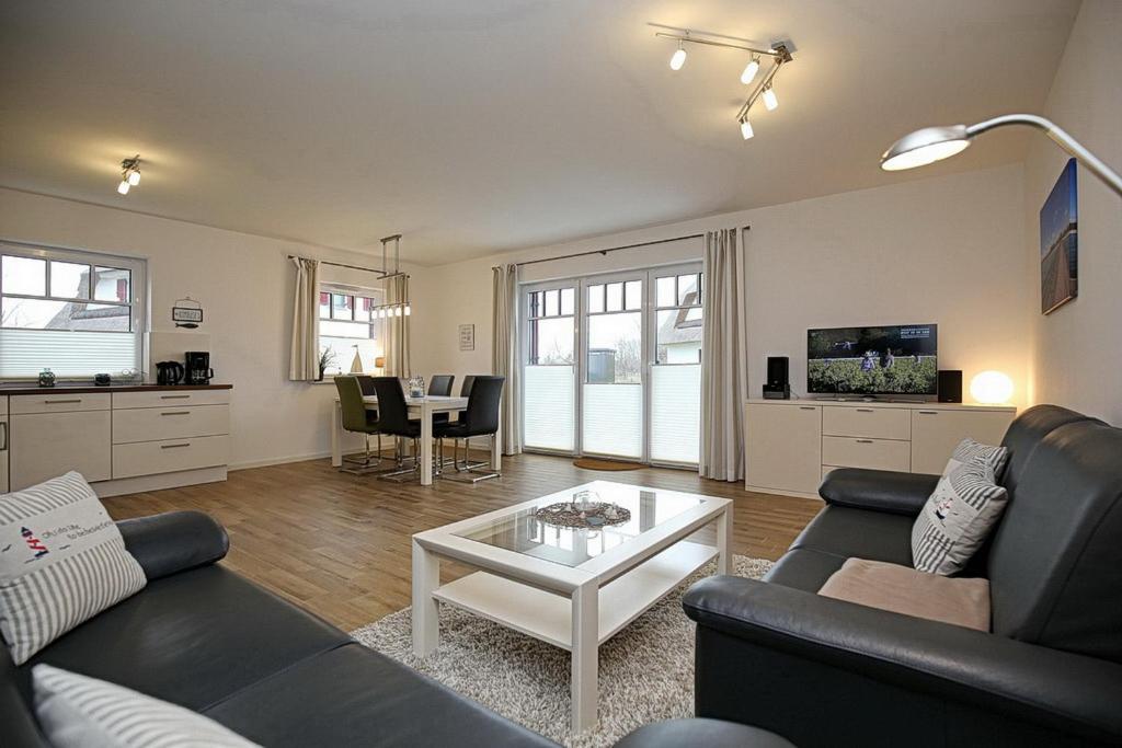 uma sala de estar com um sofá e uma mesa em Reethaus Am Mariannenweg 17a em Boltenhagen