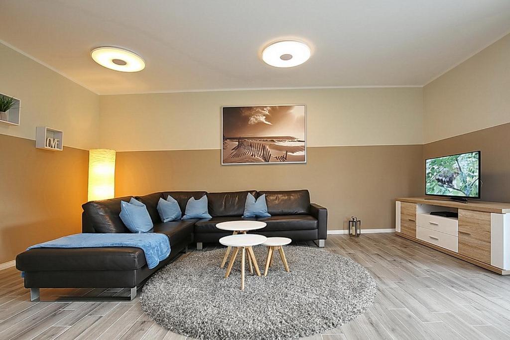 a living room with a couch and a table at Reethaus Am Mariannenweg 20b in Boltenhagen