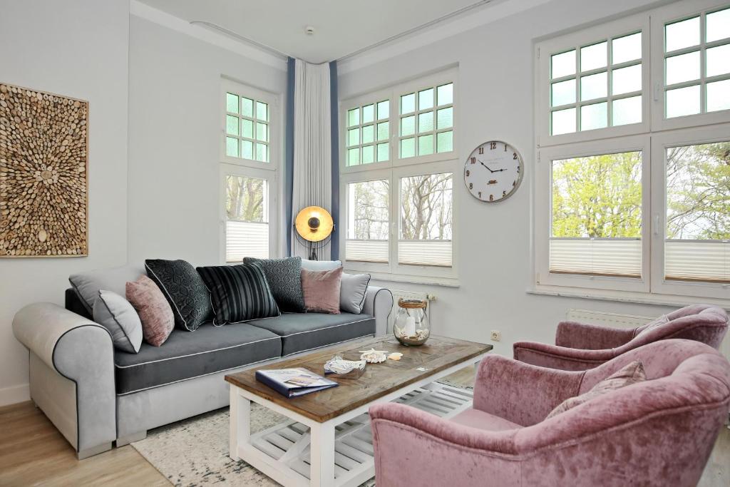 奥斯赛拜-屈隆斯博恩La Mer Wohnung 07的客厅里有一张沙发、两把椅子和一张桌子