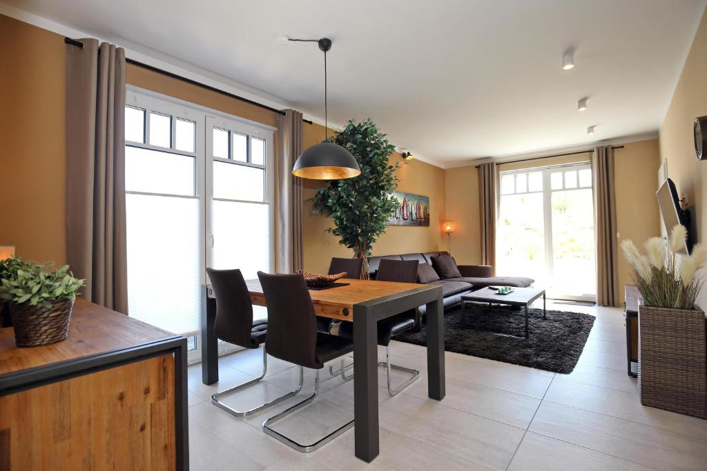 a dining room with a table and a couch at Haus am Wald Wohnung Sommer in Wittenbeck
