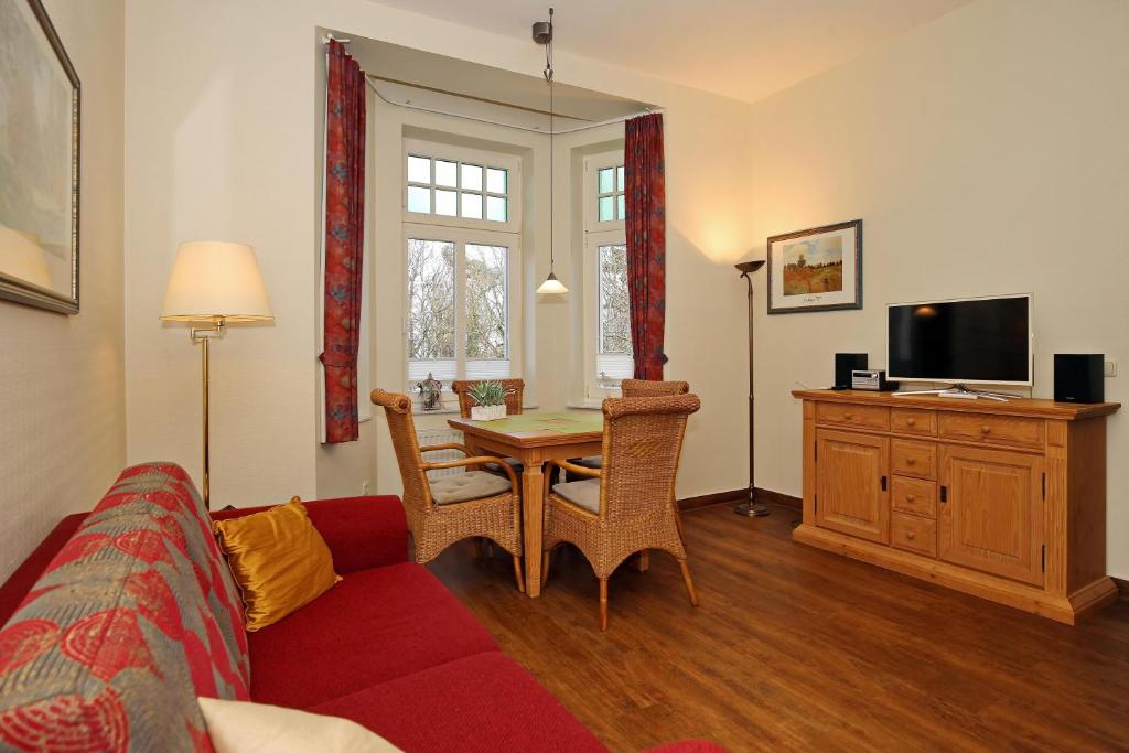 uma sala de estar com um sofá, uma mesa e uma televisão em La Mer Wohnung 08 em Kühlungsborn