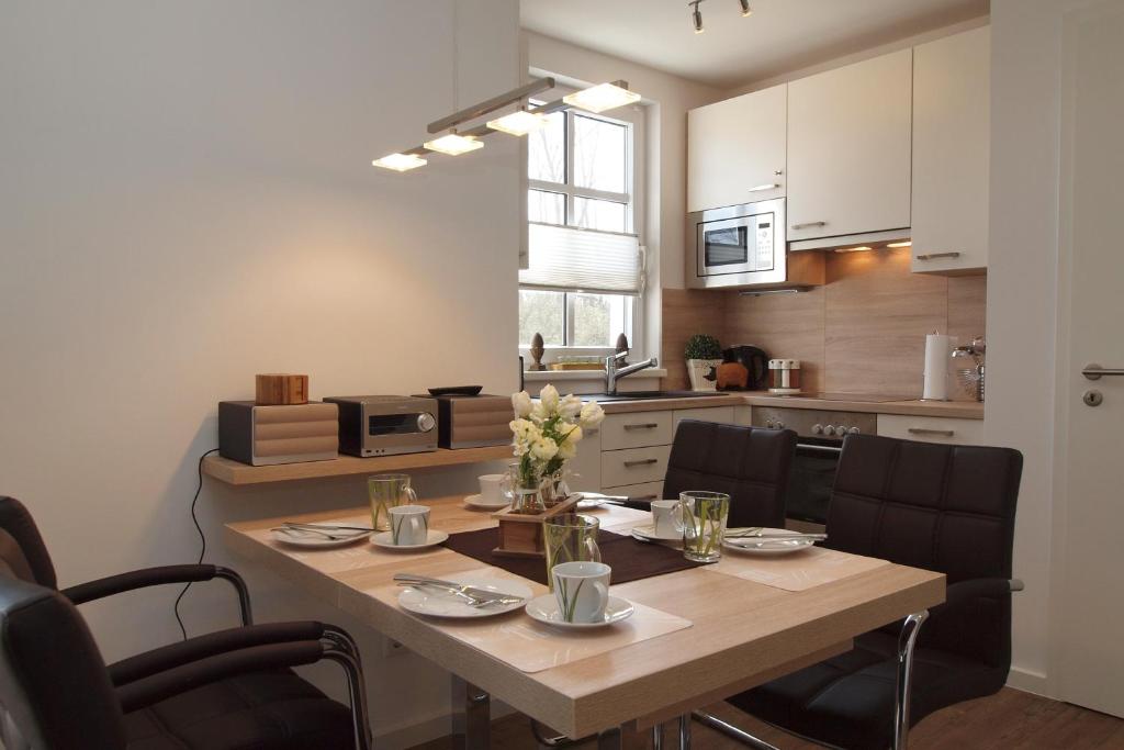 eine Küche und ein Esszimmer mit einem Tisch und Stühlen in der Unterkunft Residenz von Flotow Wohnung 09 in Heiligendamm