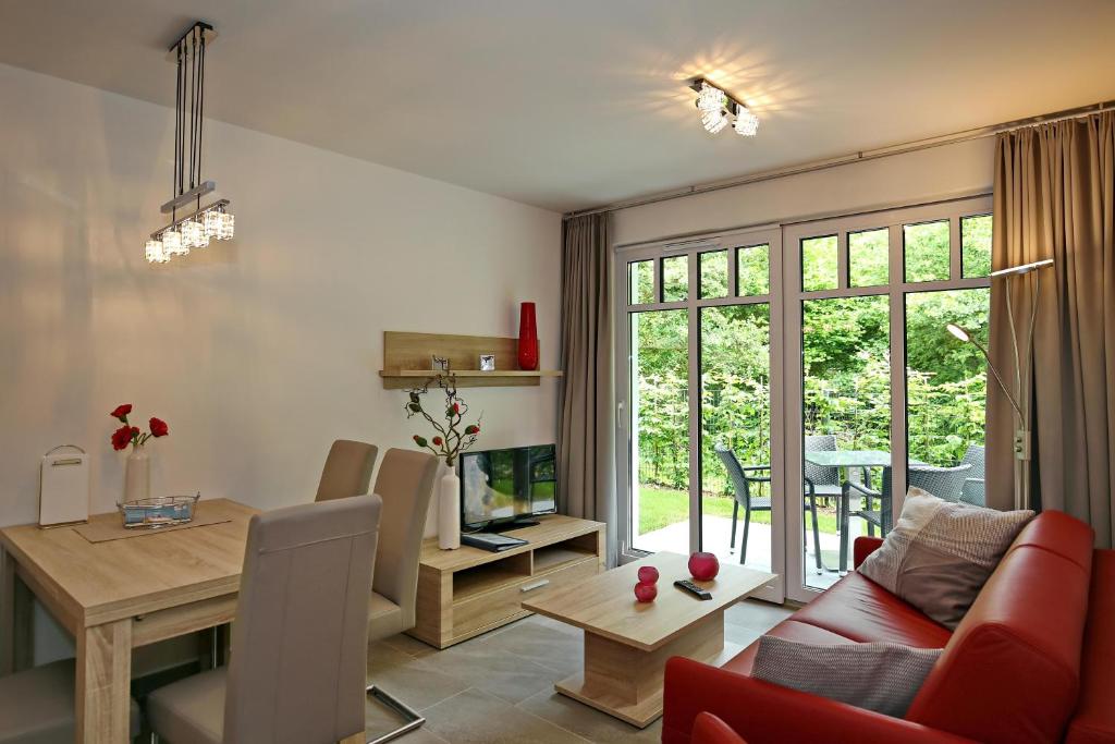 ein Wohnzimmer mit einem roten Sofa und einem Tisch in der Unterkunft Linden-Palais Wohnung 06 in Heiligendamm