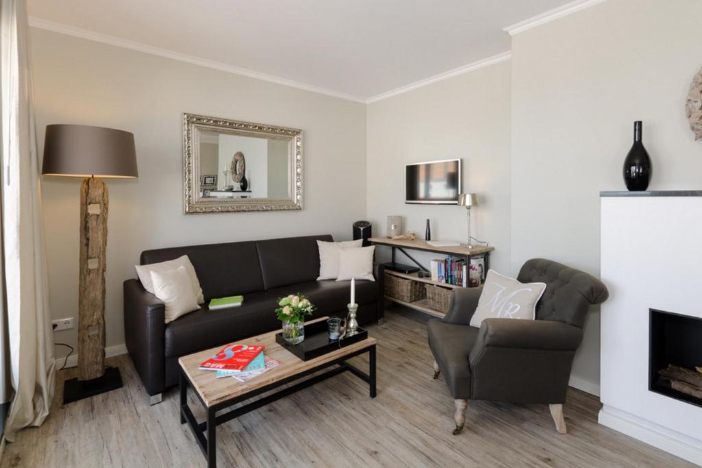 ein Wohnzimmer mit einem Sofa und einem Tisch in der Unterkunft Villa Sanddorn Wohnung 11 in Börgerende-Rethwisch