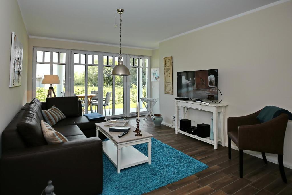 ein Wohnzimmer mit einem Sofa und einem TV in der Unterkunft Linden-Palais Wohnung 03 in Heiligendamm