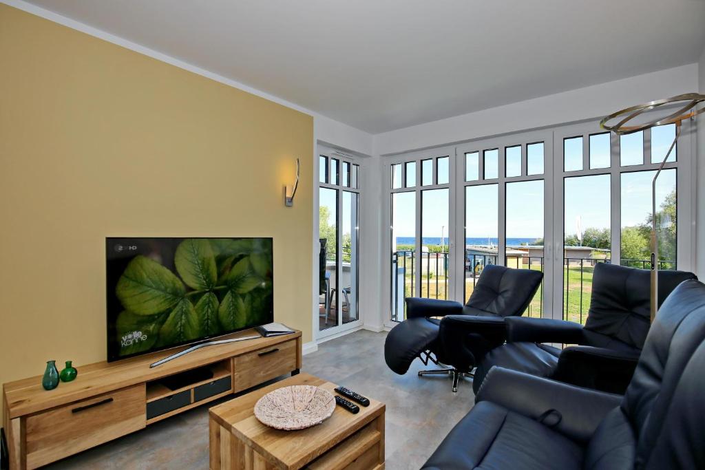 ein Wohnzimmer mit einem Sofa und einem TV in der Unterkunft Linden-Palais Wohnung 18 in Heiligendamm