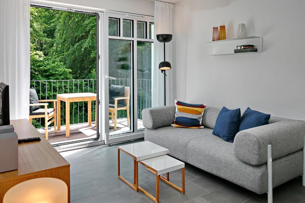 sala de estar con sofá y balcón en Linden-Palais Wohnung 21, en Heiligendamm