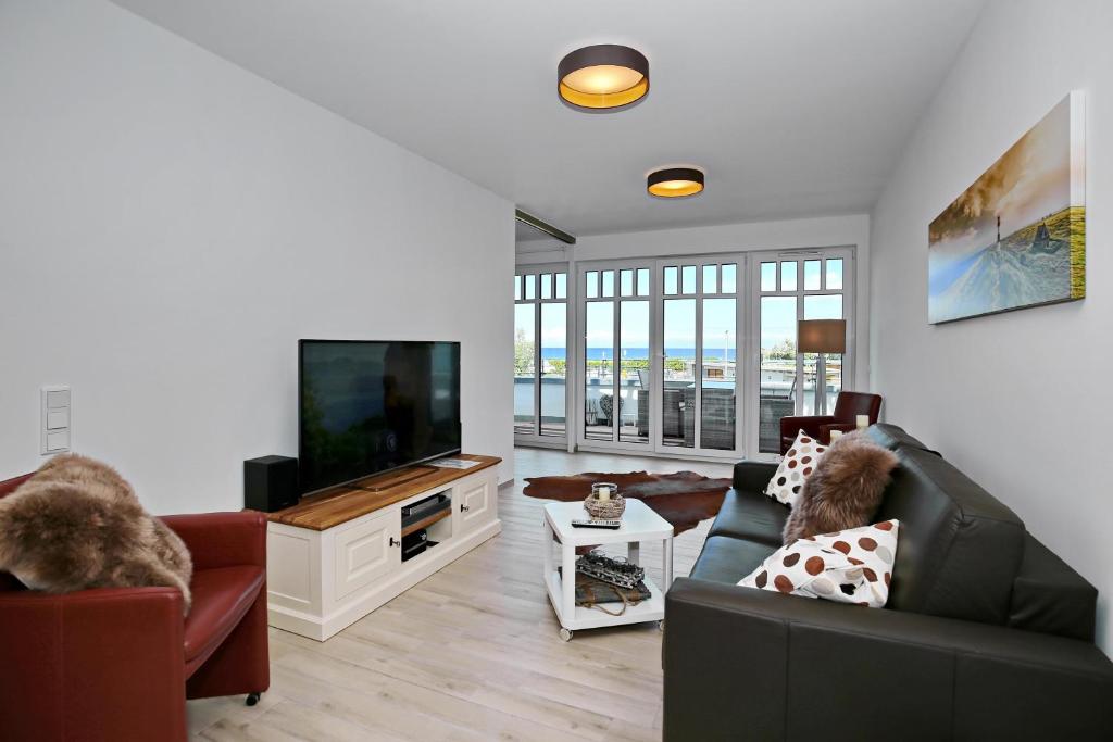 ein Wohnzimmer mit einem Sofa und einem Flachbild-TV in der Unterkunft Linden-Palais Wohnung 16 in Heiligendamm