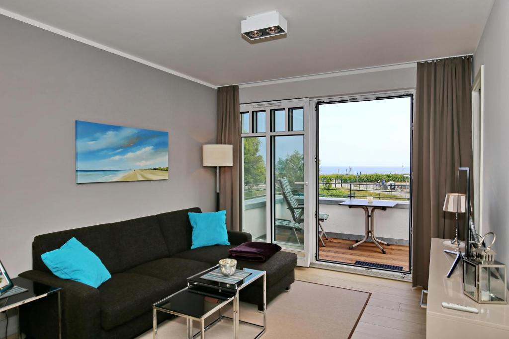 ein Wohnzimmer mit einem Sofa und einem Balkon in der Unterkunft Linden-Palais Wohnung 15 in Heiligendamm