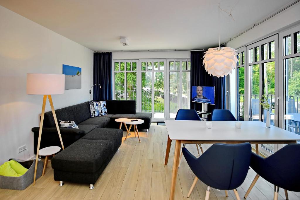 sala de estar con sofá, mesa y sillas en Linden-Palais Wohnung 29, en Heiligendamm