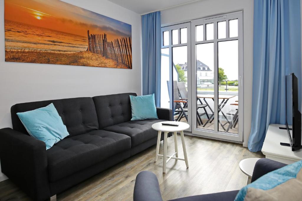 ハイリゲンダムにあるLinden-Palais Wohnung 31のリビングルーム(黒いソファ、バルコニー付)