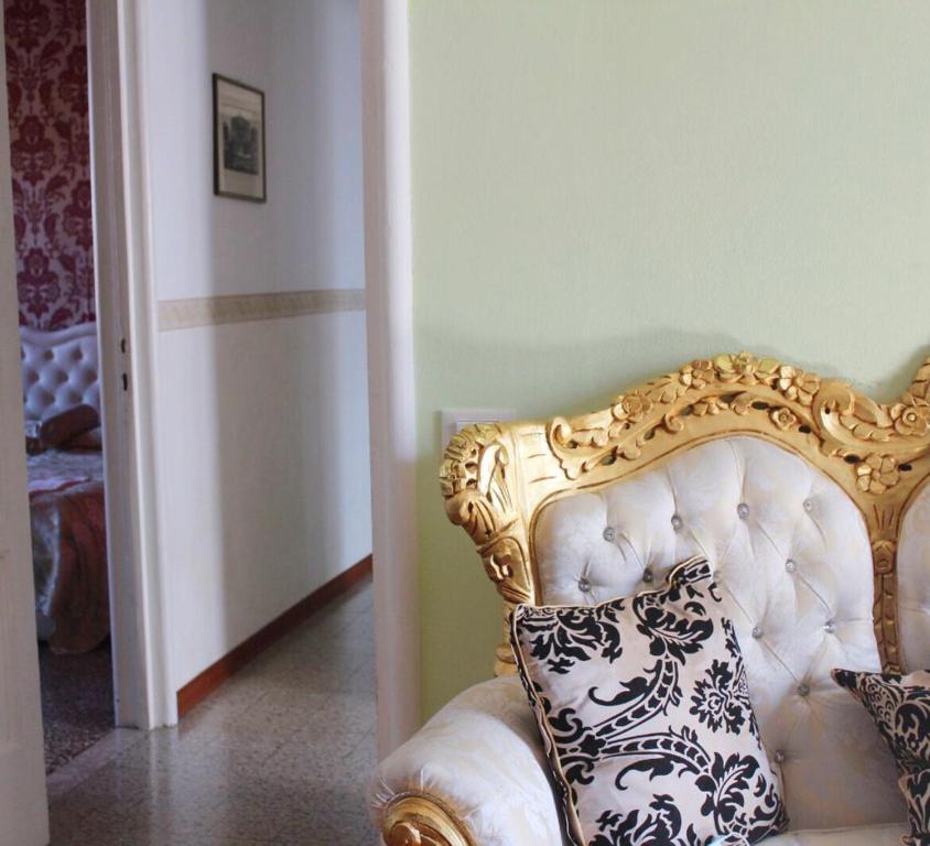 威尼斯的住宿－The Golden Apartment，金色和白色的椅子,上面有枕头