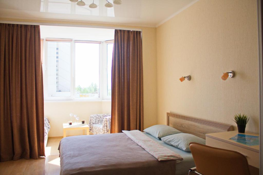 a hotel room with a bed and a window at PaulMarie Apartments on Prs. Stroiteley in Vitebsk