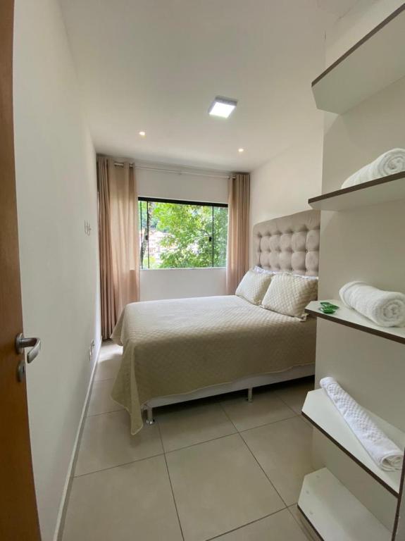 a bedroom with a large bed and a window at Aconchego Serra Imperial-101 in Petrópolis