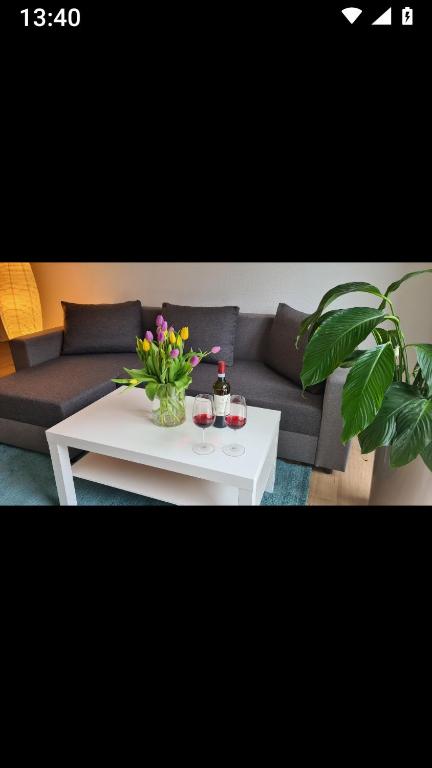 a living room with a couch and a table with flowers at Ferienwohnung Maurer in Bad Überkingen