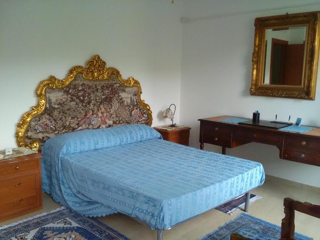 1 dormitorio con cama azul y espejo en VILLA MONICA Diano San Pietro (IM) Italy en Diano San Pietro