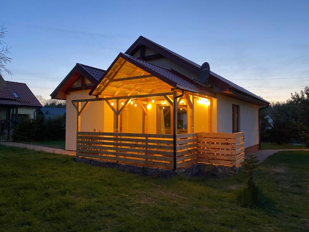 a small house with lights on it in a yard at Leśna Oaza in Sasino