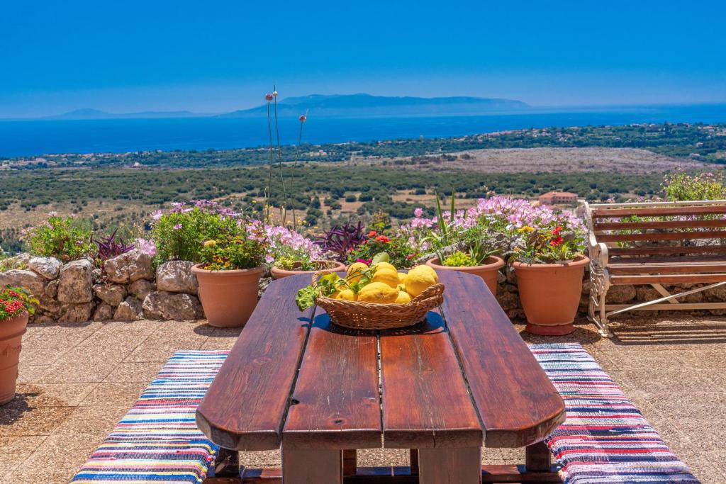 una mesa de madera con una cesta de fruta. en Saint George Castle Villa with sea view, en Cefalonia