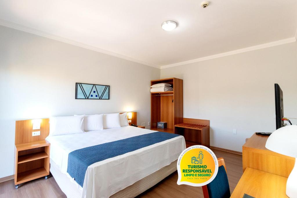 a hotel room with a bed and a tv at Bristol Zaniboni Mogi Mirim in Mogi Mirim