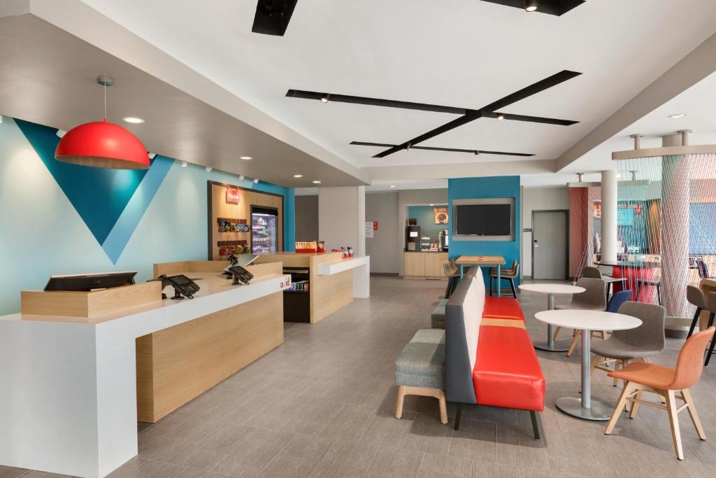 a lobby with a waiting area with tables and chairs at Avid hotels - Ft Lauderdale Airport - Cruise, an IHG Hotel in Fort Lauderdale