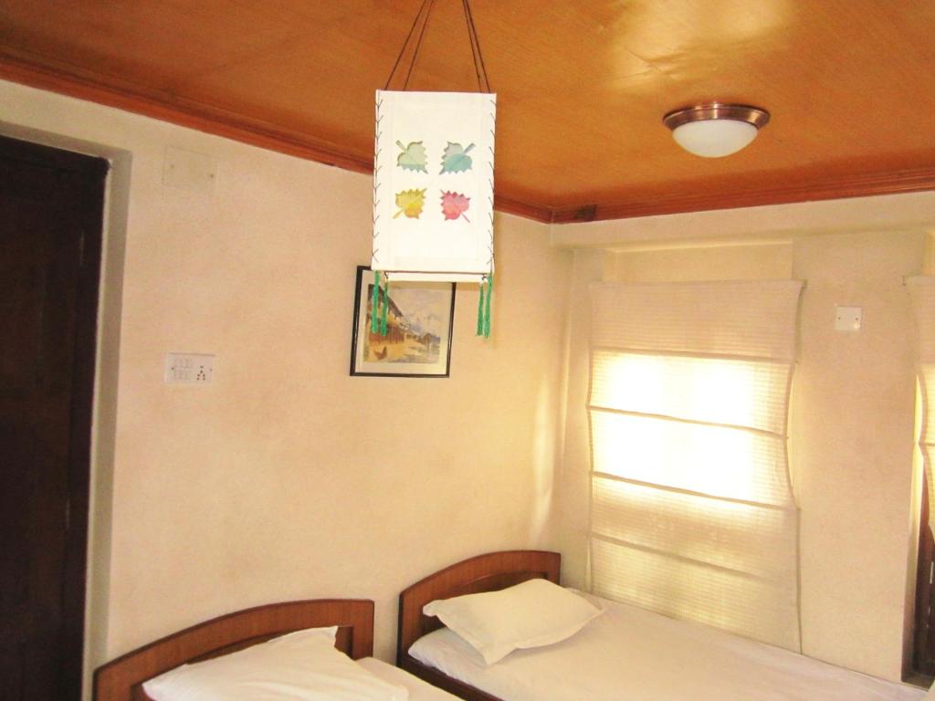 a small room with two beds and a window at Ecotel Guest House in Bhaktapur
