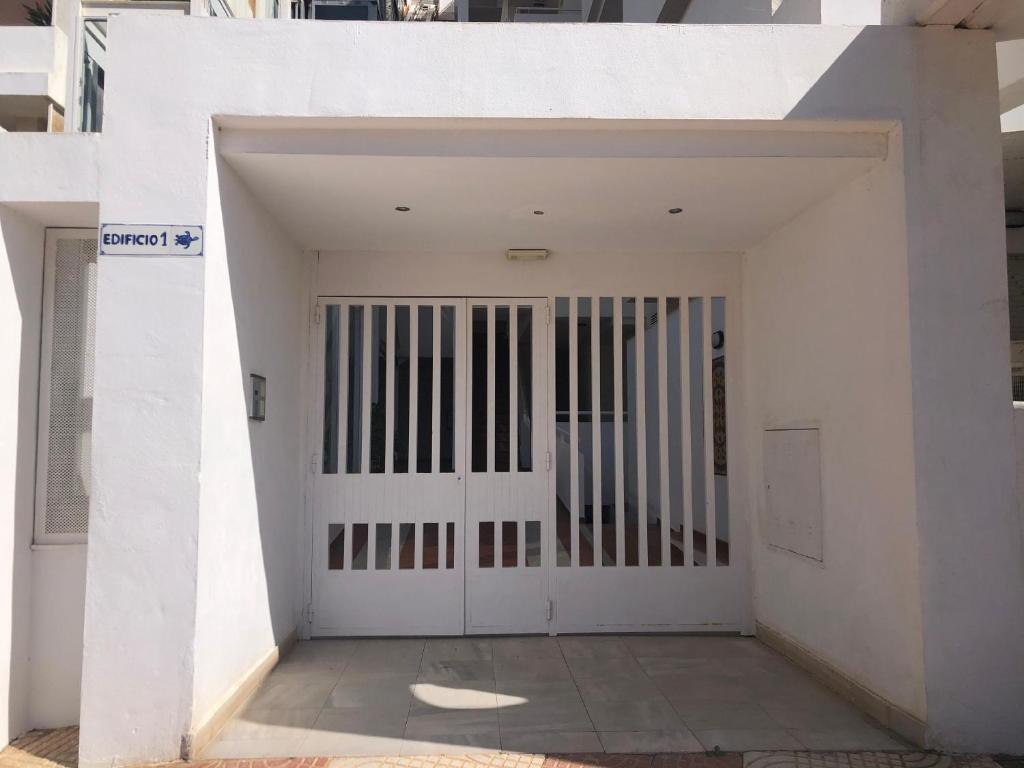 een witte deur met een poort in een gebouw bij Tortugas 16 in Carboneras