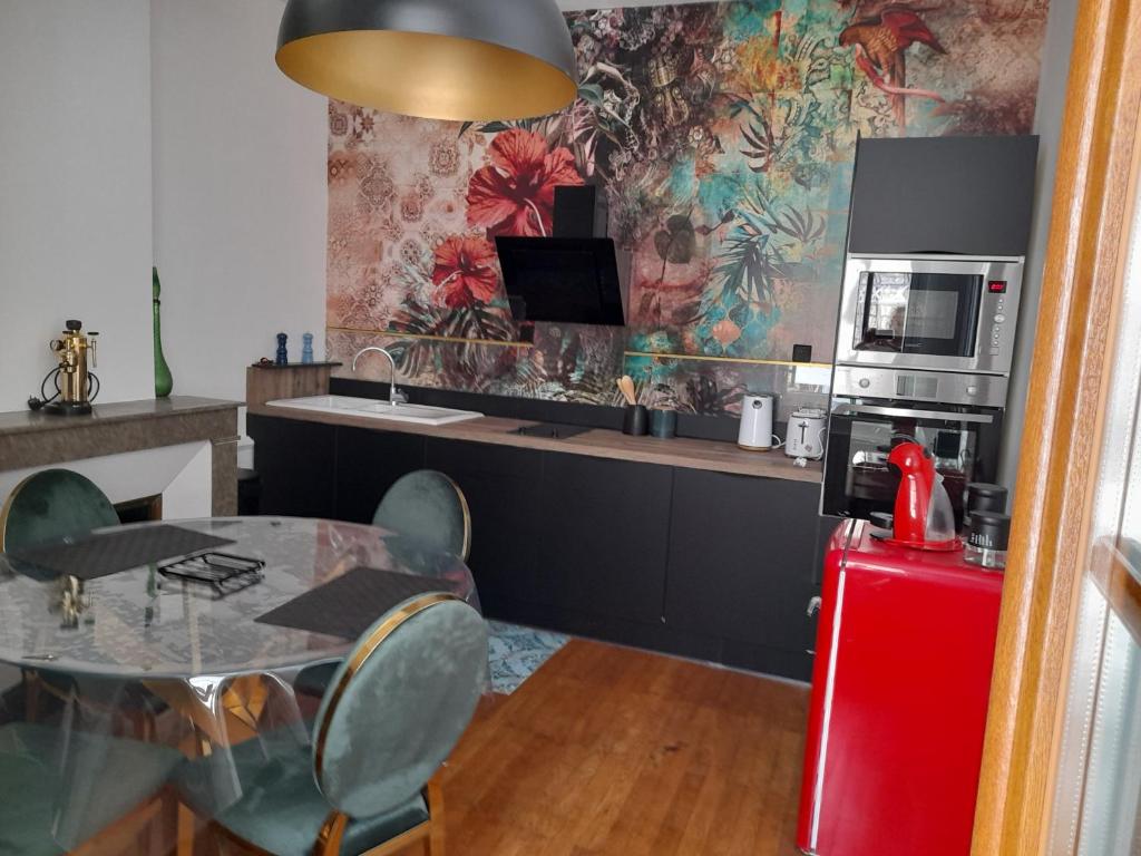 uma cozinha com uma mesa, um micro-ondas e um frigorífico em LA KAIGA em Saint-Rambert-en-Bugey