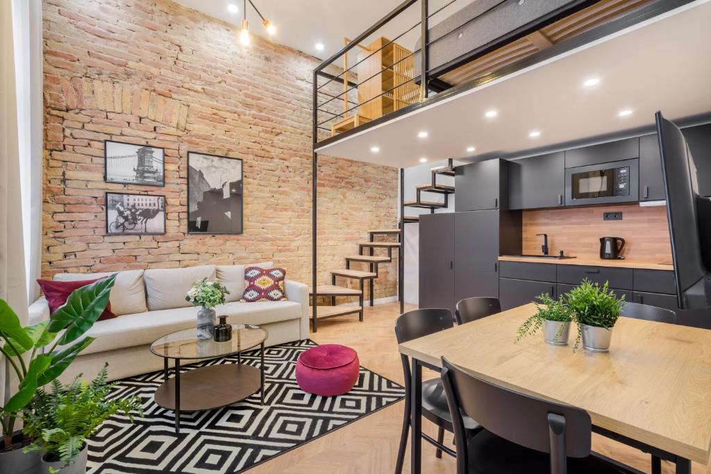una sala de estar de planta abierta con una pared de ladrillo en K33- Boutique Apartments, Best Location, by BQA en Budapest