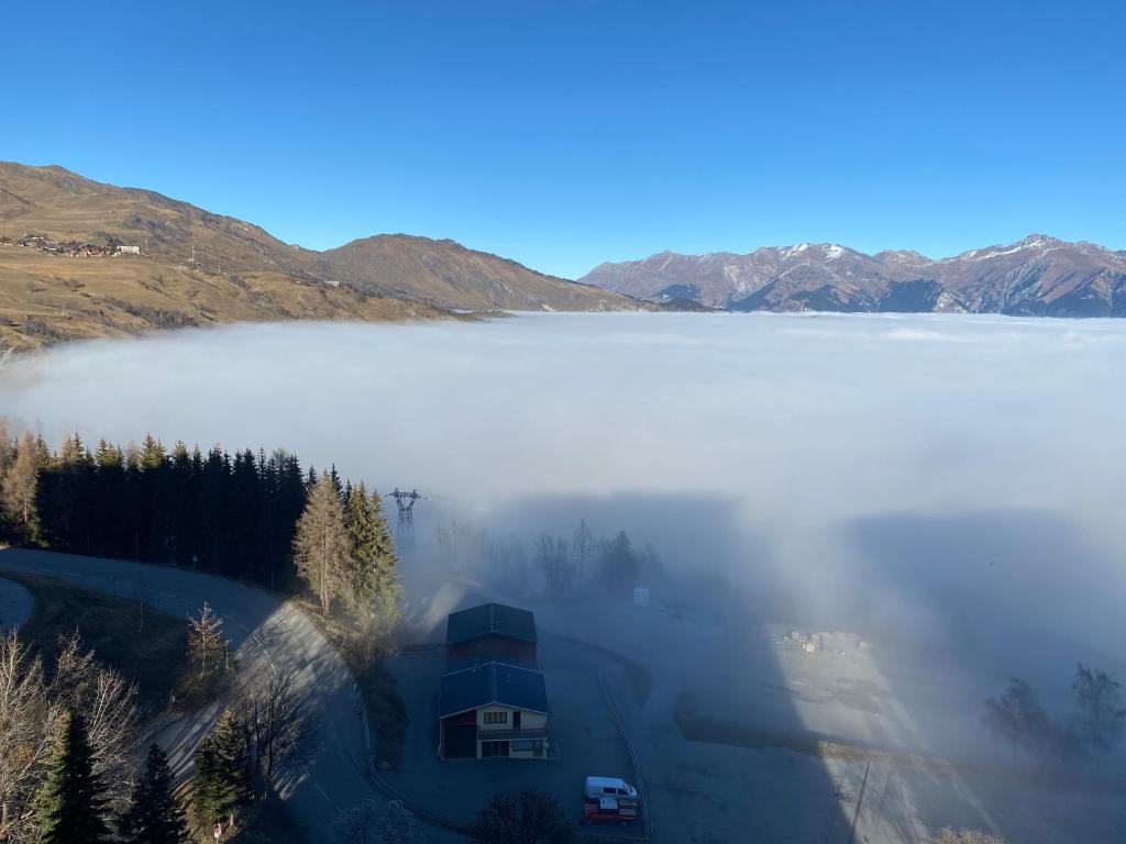 a house in the middle of a lake in the fog at Le Vostok Zodiaque Soyouz in Le Corbier