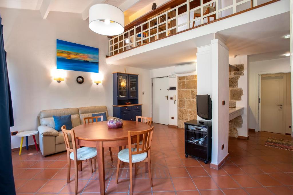 a living room with a table and chairs and a tv at Ferret Apartment in Alghero