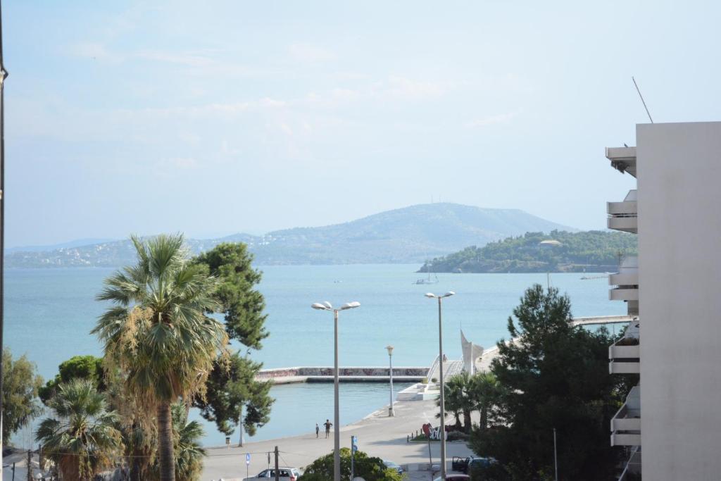 een uitzicht op een strand met palmbomen en het water bij My sweet home near to the sea in Volos