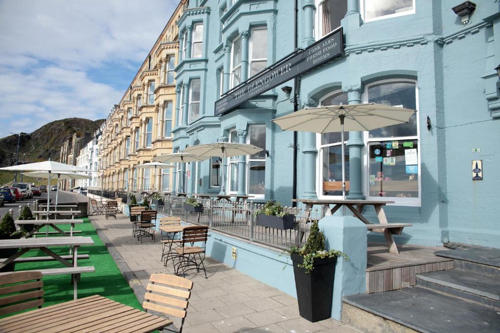 a blue building with tables and chairs and an umbrella at The Glengower in Aberystwyth