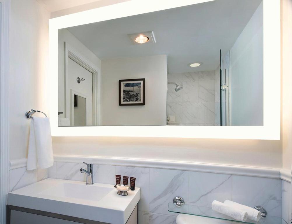 
a bathroom with a sink, mirror, and bathtub at Inn at Union Square in San Francisco
