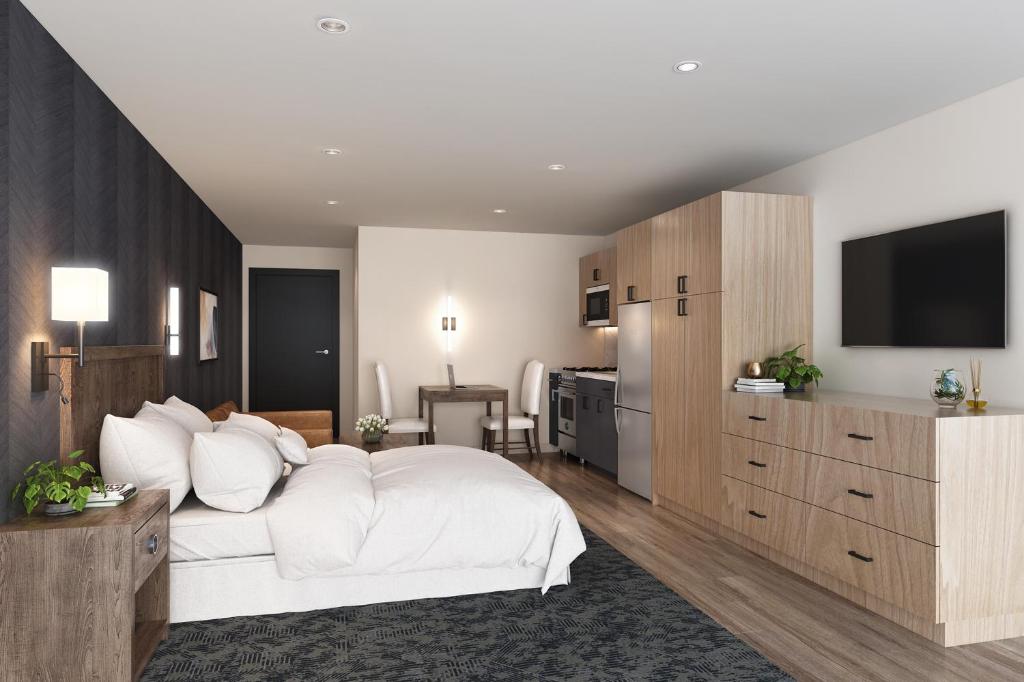 a bedroom with a white bed and a television at Residences at Solomon Pond in Marlborough